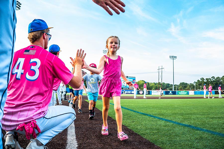 Photo of baseball players high-fiving the kids