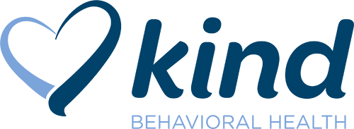Kind Behavioral Health Logo - Dark blue serif type and light blue sans-serif type with heart icon to left