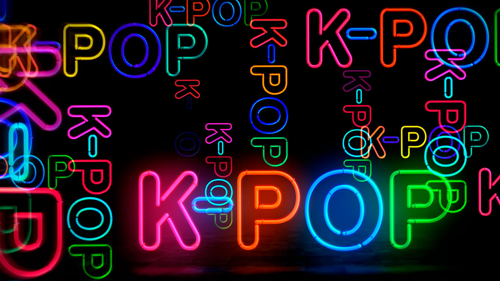 Graphic showing illustration multi-colored neon spelling K-POP on black background